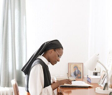 A nun is doing paperwork at a desk at an abbey in Arizona