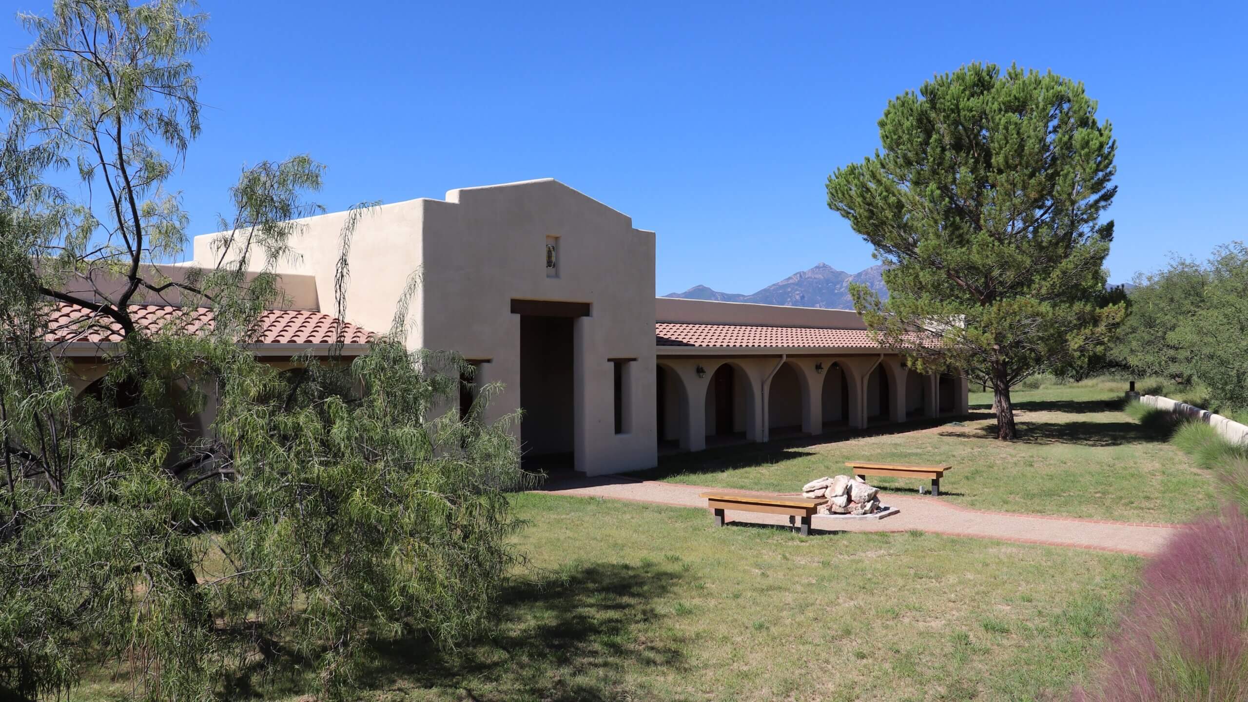An abbey in Arizona with a lawn that has been well maintained by volunteer workers
